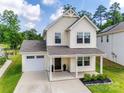 Inviting two-story home featuring a covered porch, attached garage, and neatly landscaped front yard at 3855 Tersk Dr, Midland, NC 28107