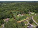 An aerial view shows the property, surrounded by mature trees, featuring a pool and highlighted property lines at 394 E Goldmine Rd, Wadesboro, NC 28170