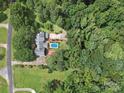 Aerial view of a secluded home nestled among mature trees with a private pool at 394 E Goldmine Rd, Wadesboro, NC 28170