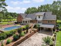 Expansive home exterior showcasing a pool, well-kept landscaping, a covered garage, and an elevated deck at 394 E Goldmine Rd, Wadesboro, NC 28170