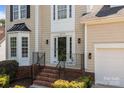 Close-up of the front door, showcasing sidelights, black hardware, and brick stairs at 4519 Rock Stream Dr, Charlotte, NC 28269