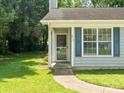 Inviting front entrance with a well-lit porch, screen door, and beautifully landscaped surroundings at 5019 Poplar Glen Dr, Matthews, NC 28104