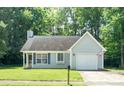 Classic single-story home featuring a well-kept lawn, attached garage, and welcoming front entry at 5019 Poplar Glen Dr, Matthews, NC 28104