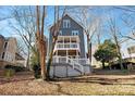 Back exterior view of a two-story home with a tiered deck surrounded by mature trees at 6017 Millbury Ct, Charlotte, NC 28211