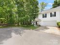 View of the charming white home surrounded by lush greenery and a driveway, offering curb appeal at 705 Torrey Pines Ln, Fort Mill, SC 29715