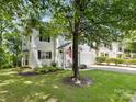 Charming white home featuring a well-kept lawn and inviting front porch with rocking chairs at 705 Torrey Pines Ln, Fort Mill, SC 29715