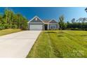 Attractive single-Gathering home with a well-kept lawn, an attached garage, and tasteful gray siding at 10180 Lakeshore Dr, Lancaster, SC 29720