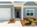 Close-up of home's front door with stone accents, white columns, and a well-manicured landscape at 10180 Lakeshore Dr, Lancaster, SC 29720