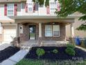 Inviting front porch with stone accents and manicured landscaping at 107 Ameena Chase Trl, Mooresville, NC 28117