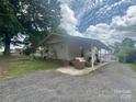 Inviting outdoor space with comfortable seating, a covered patio, and a gravel driveway leading to a detached garage at 1107 Crestfield Dr, Lancaster, SC 29720