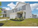 Charming two-story home featuring gray siding, a two-car garage, landscaped front yard, and a welcoming front porch at 120 Parson Ln, Statesville, NC 28625