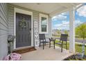 Inviting front porch with seating, a decorative wreath on the front door, and manicured landscaping at 120 Parson Ln, Statesville, NC 28625