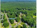 Aerial view of a home nestled in a lush, green neighborhood with mature trees and winding roads at 125 Highland Forest Dr, Clover, SC 29710
