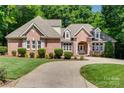 Charming brick home with lush lawn, landscaped garden and circular driveway at 125 Highland Forest Dr, Clover, SC 29710
