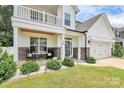 Charming front porch with rocking chairs, stone accents, and landscaped greenery, inviting relaxation and curb appeal at 139 Suggs Mill Dr, Mooresville, NC 28115