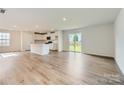 Open-concept living room with hardwood flooring and sliding glass doors leading to the backyard at 144 Astor St, Troutman, NC 28166