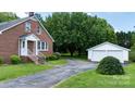 Brick home with a long driveway leading to a detached two-car garage, complemented by mature landscaping at 1520 21St Ne Ave, Hickory, NC 28601