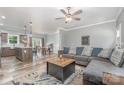 A cozy living room featuring a large sectional sofa, modern ceiling fan, and open view to the kitchen at 1870 Hwy 49 None, New London, NC 28127