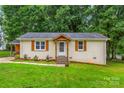 Charming single-story home with a well-manicured lawn and a welcoming front entrance with decorative wood at 21322 Mccall St, Cornelius, NC 28031