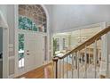 Elegant foyer with hardwood floors, staircase, and a view into the sunlit dining room at 2317 Houston Branch Rd, Charlotte, NC 28270