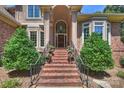 Inviting front entrance featuring a brick staircase, arched entryway, and manicured landscaping at 2317 Houston Branch Rd, Charlotte, NC 28270