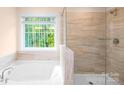 Luxurious bathroom with a soaking tub, tiled shower, and a large window offering natural light at 259 Miramar Dr, York, SC 29745