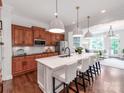 Open concept kitchen features a large island, marble countertops, wooden cabinetry, and stainless steel appliances at 3036 Luke Crossing Dr, Charlotte, NC 28226