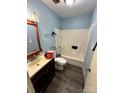 Bathroom with laminate floor, blue walls, toilet, vanity, and shower/tub combo at 3396 Farm Lake Sw Dr, Concord, NC 28027