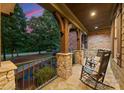 Cozy front porch featuring stone columns, rocking chairs, and a peaceful outdoor seating area at 408 Covington Xing, Matthews, NC 28104