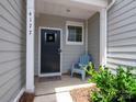 Inviting front porch featuring a cozy blue chair, decorative wreath, and well maintained landscaping at 4177 Steel Way, Sherrills Ford, NC 28673