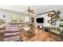 Bright living room featuring hardwood floors, a comfortable couch, and large windows at 4312 Mary Point Rd, Monroe, NC 28110