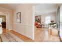 Hallway with hardwood floors leading to a living room with neutral walls and classic decor at 5014 Quail Canyon Dr, Charlotte, NC 28226