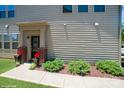 Inviting front entrance with a covered porch and colorful potted plants at 5391 Orchid Bloom Dr, Indian Land, SC 29707