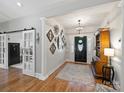 Inviting foyer featuring wood floors, decorative mirrors, shiplap accent wall, and stylish chandelier at 5921 Meadowmere Dr, Monroe, NC 28110