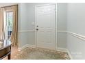 Welcoming entryway with white door, neutral walls, and stylish rug at 7118 Powder Mill Pl, Charlotte, NC 28277