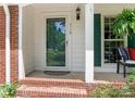 Inviting front porch with brick steps, white columns, and green shutters at 7118 Powder Mill Pl, Charlotte, NC 28277