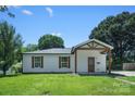 Quaint single-story home with a well-maintained lawn and inviting covered front porch with timber accents at 1122 Oconee Ave, Rock Hill, SC 29732