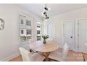 Bright dining area with a modern chandelier, table, white chairs, and natural light at 1223 E 16Th St # 13, Charlotte, NC 28205