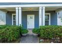 Inviting front porch with white columns and neatly trimmed shrubs in decorative pots at 1226 Rising Oak Dr, Charlotte, NC 28206
