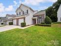 Two-story townhome featuring a well-maintained lawn and a two-car garage at 12415 Stratfield Place Cir, Pineville, NC 28134
