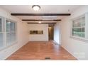 Inviting living area featuring hardwood floors, exposed beam ceiling, and large window at 1409 Turner Dr, Gastonia, NC 28052
