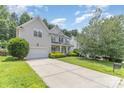 Spacious home featuring a long driveway, attached garage, and well-maintained lawn, perfect for families and entertaining at 14333 Maclauren Ln, Huntersville, NC 28078