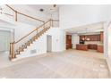 Open-concept living room features a soaring ceiling, a staircase, and seamless flow into the kitchen, great for entertaining at 14333 Maclauren Ln, Huntersville, NC 28078