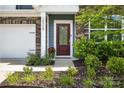 Inviting front entrance with stone accents, a red door, and landscaped garden beds adding curb appeal at 15119 Oleander Dr, Charlotte, NC 28278