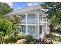 Charming two-story home featuring a double porch, light blue siding, and lush landscaping at 15838 Trenton Place Rd, Huntersville, NC 28078