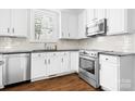 Bright kitchen with white cabinets, stainless steel appliances, and dark countertops at 15838 Trenton Place Rd, Huntersville, NC 28078