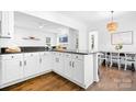 Open kitchen with white cabinets, dark countertops, and a view into the dining area at 15838 Trenton Place Rd, Huntersville, NC 28078