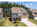 Beautiful home with brick and gray siding, an attached two-car garage, and a well-maintained lawn with beautiful landscaping at 169 Rooster Tail Ln, Troutman, NC 28166