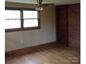 Bright bedroom featuring hardwood floors, a ceiling fan and ample natural light from a large window at 1700 Old Spencer Mountain Rd, Dallas, NC 28034