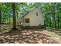 View of the side of the home with brick foundation and mature trees at 203 Hickory Wood Dr, Kannapolis, NC 28083